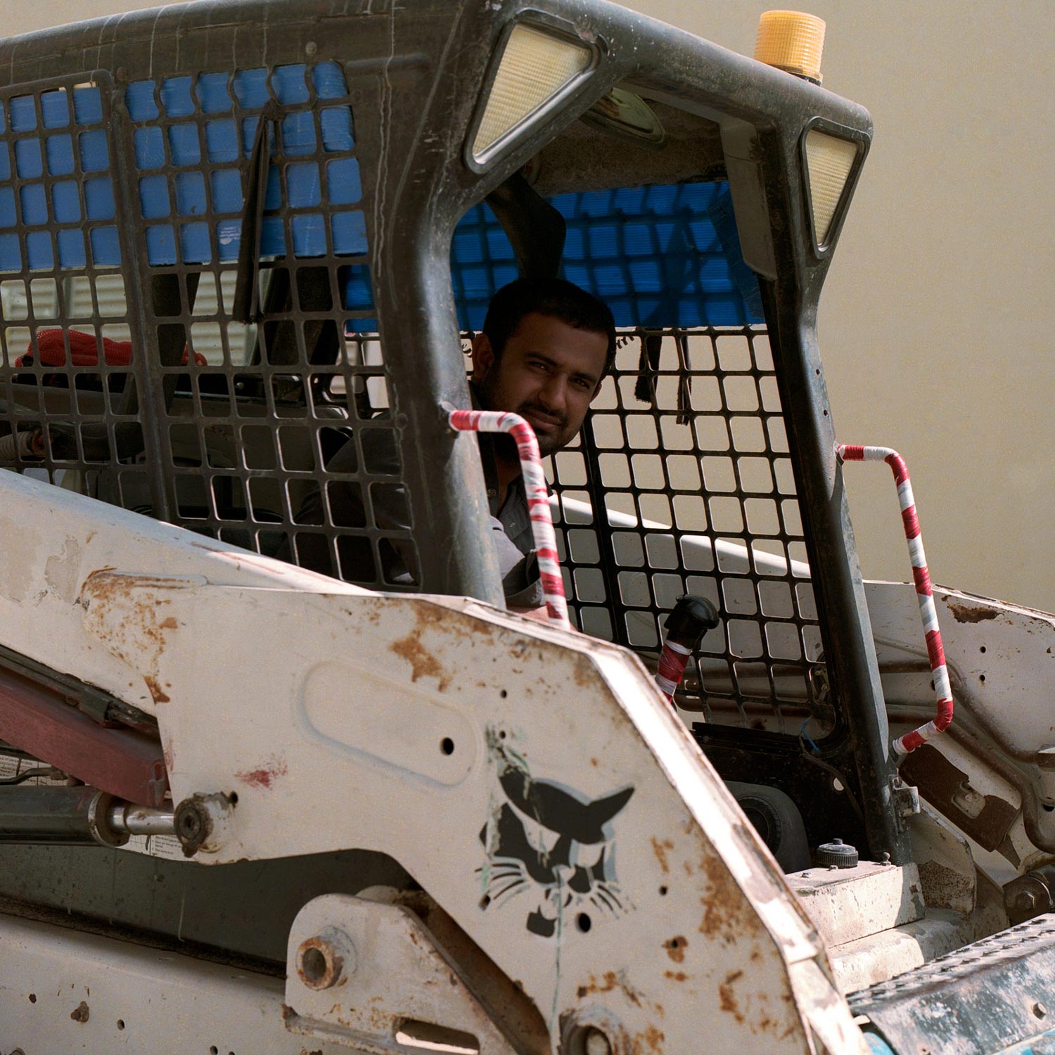 Construction worker looks out from digger machine, in Dubai.