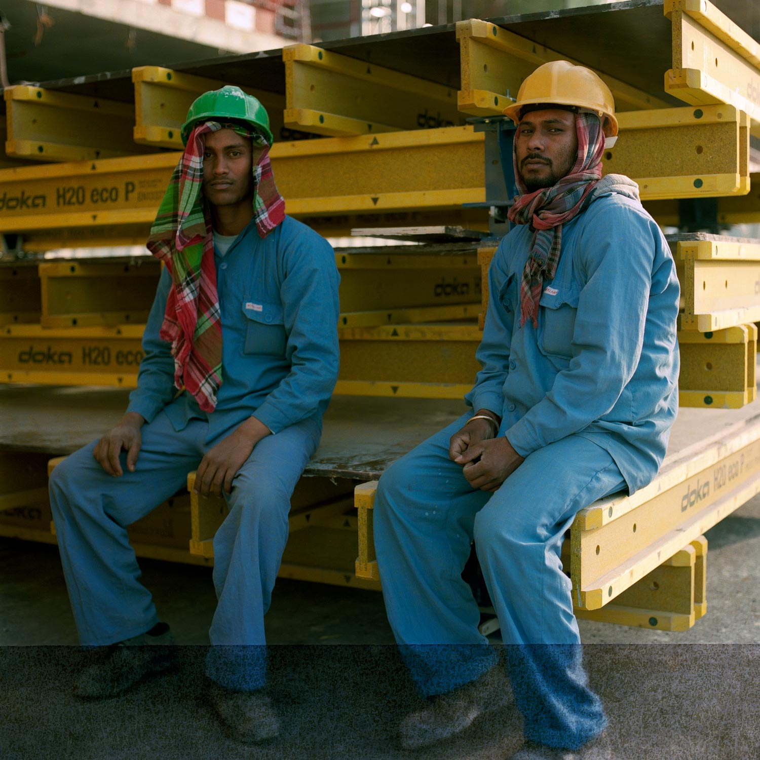 Two construction workers taking a break on a construction site in Dubai. analogue photography.