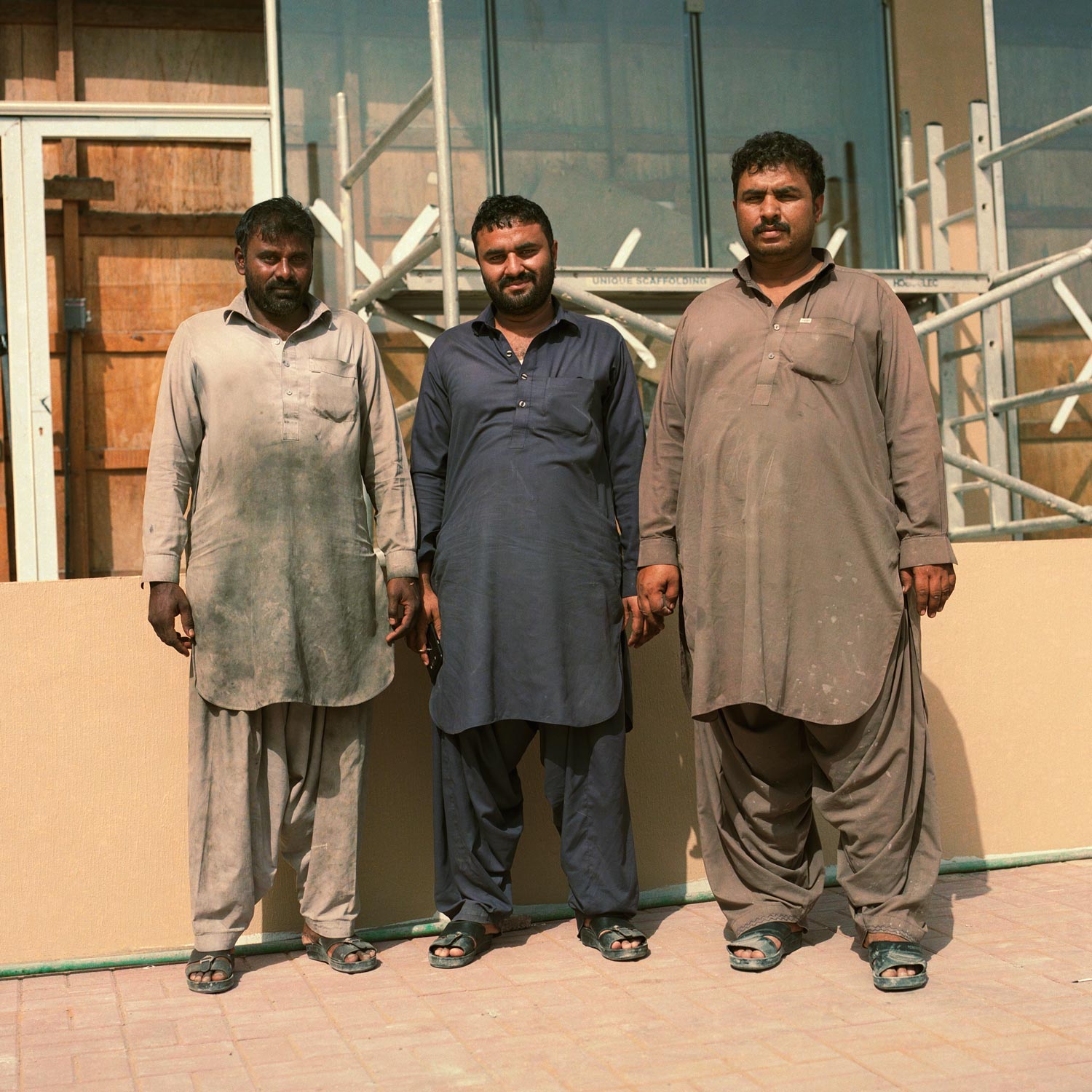 Three Indian construction workwrs on site.
